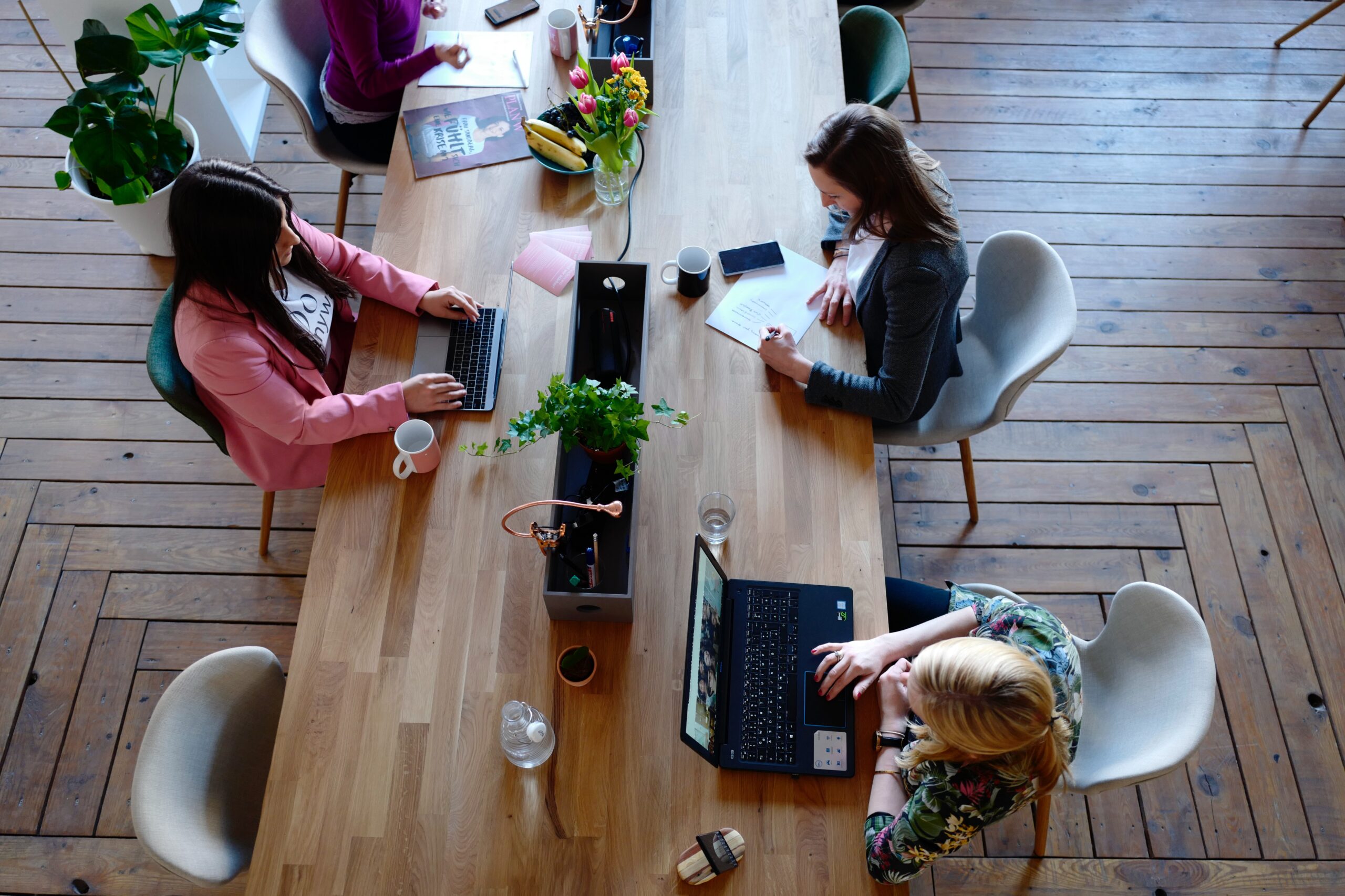 Bilden visar människor i ett coworking space eller ett kontorslandskap. Ljudabsrobenter som takabsorbenter och väggabsorbenter är viktiga för att skapa en tystare och behagligare arbetsmiljö.