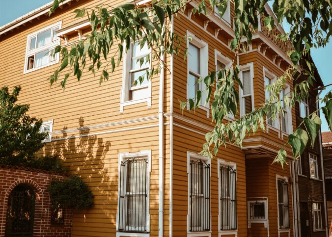 Bilden visar ett gult stort hus. Algtvätt, fasadtvätt och taktvätt underlättas genom att anlita ett proffs på taktvätt och fasadtvätt med algbehandling.